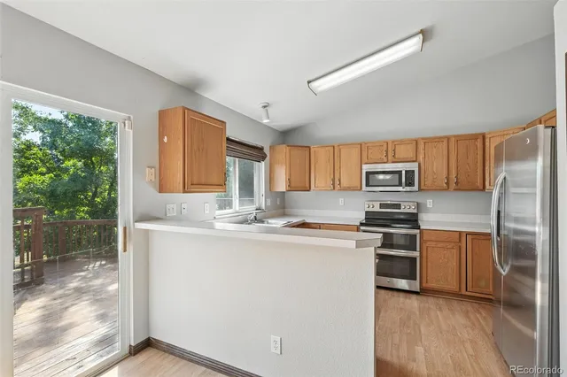 a kitchen with stainless steel appliances granite countertop a sink stove refrigerator and cabinets