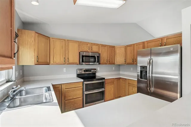 a kitchen with granite countertop a sink stainless steel appliances and cabinets
