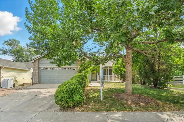 a front view of a house with a yard and tree s