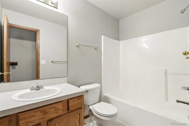 a bathroom with a toilet a sink a mirror and vanity