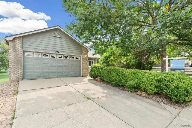 a view of house with a yard and garage