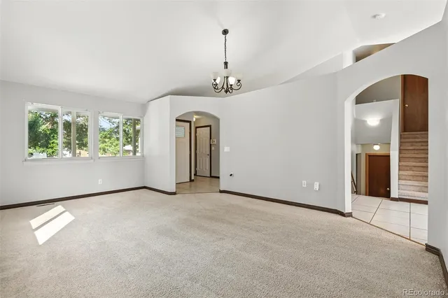 an empty room with windows and chandelier