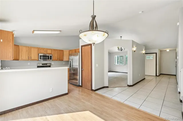 a view of a kitchen with refrigerator and cabinets