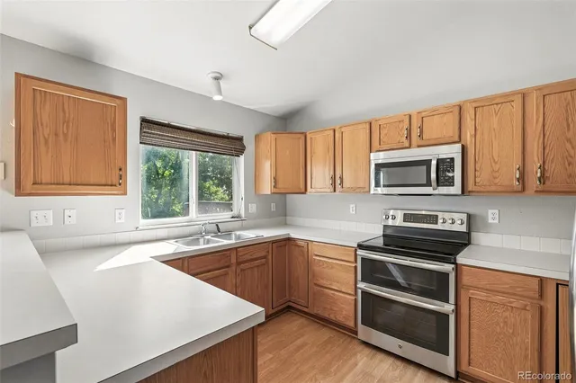 a kitchen with stainless steel appliances a stove sink and microwave