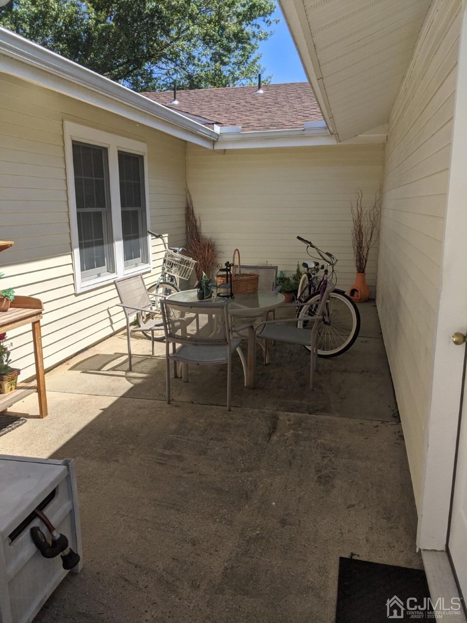 230 Convent Road, Unit A Monroe Township, NJ 08831 - Photo 21 of 22 a view of a patio with table and chairs and potted plants