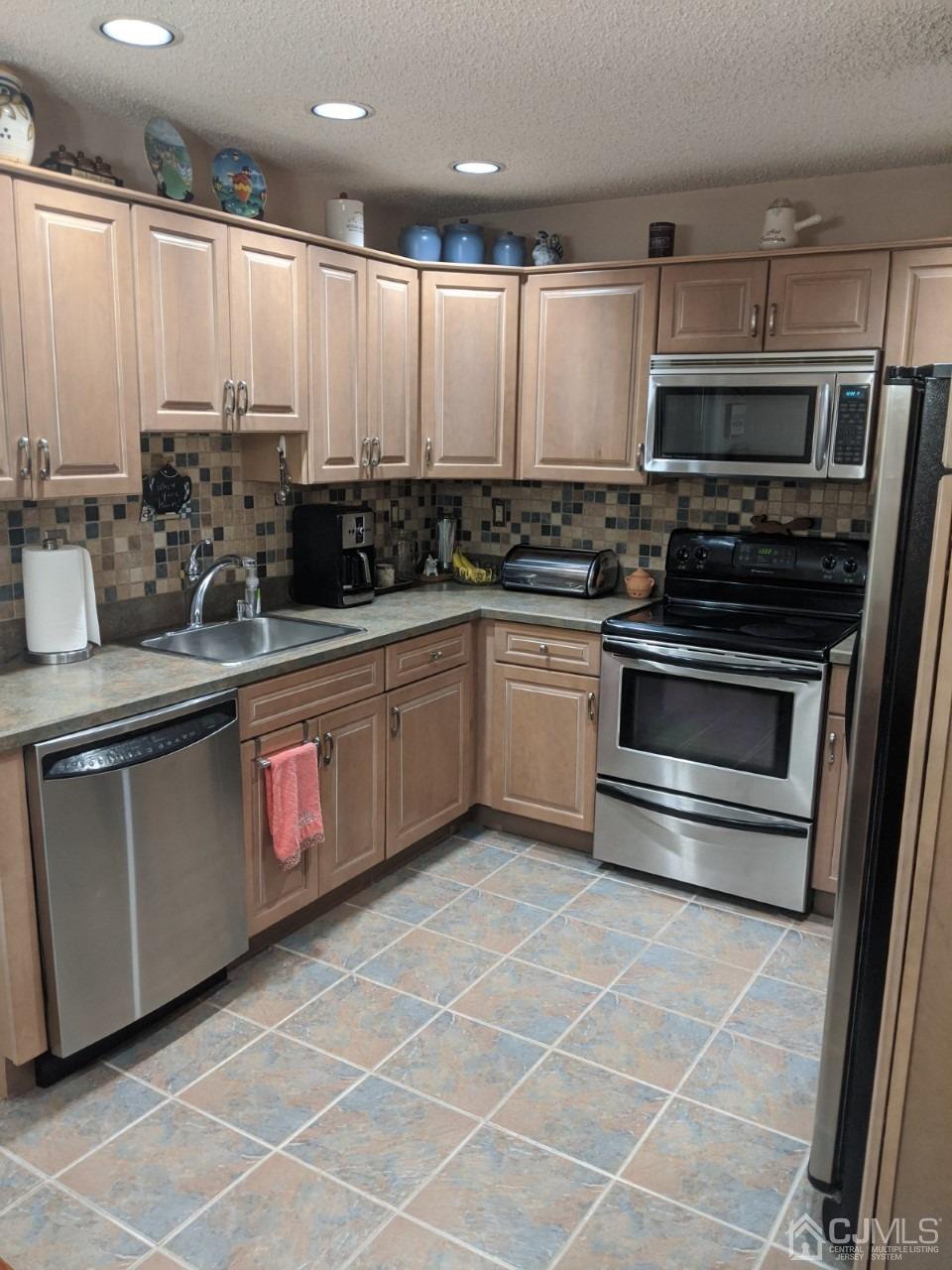 230 Convent Road, Unit A Monroe Township, NJ 08831 - Photo 7 of 22 a kitchen with granite countertop a sink stainless steel appliances and cabinets