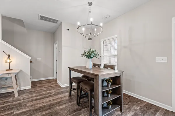 a view of a dining room with furniture a chandelier and wooden floor