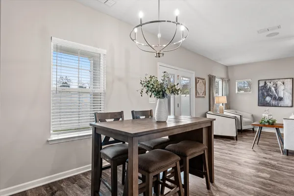 a view of a dining room with furniture wooden floor and chandelier