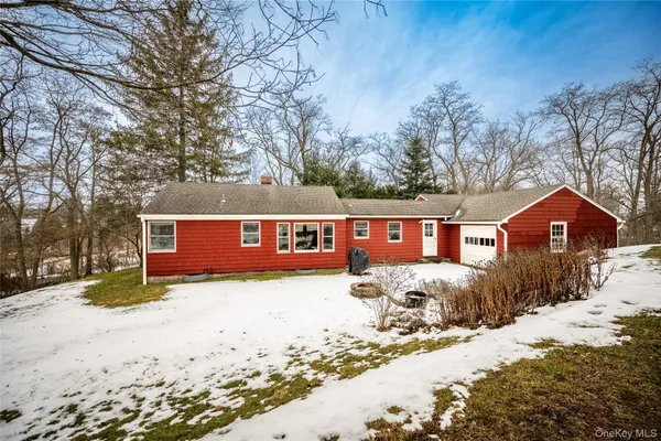 a front view of a house with a yard covered in snow