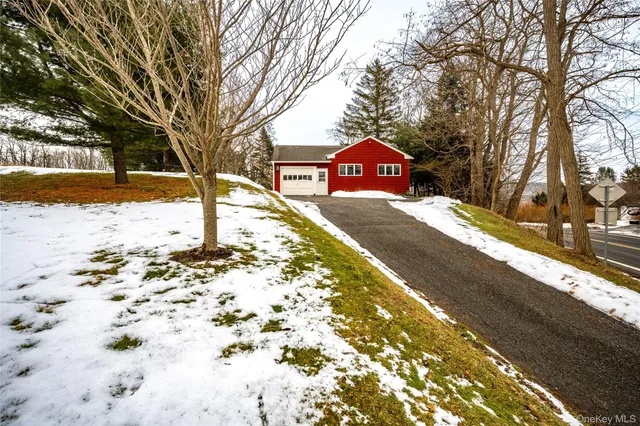 a front view of a house with a yard covered in snow