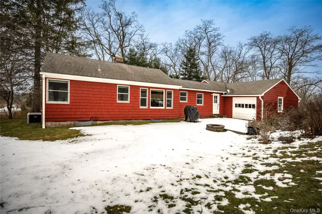 a front view of a house with a yard covered in snow
