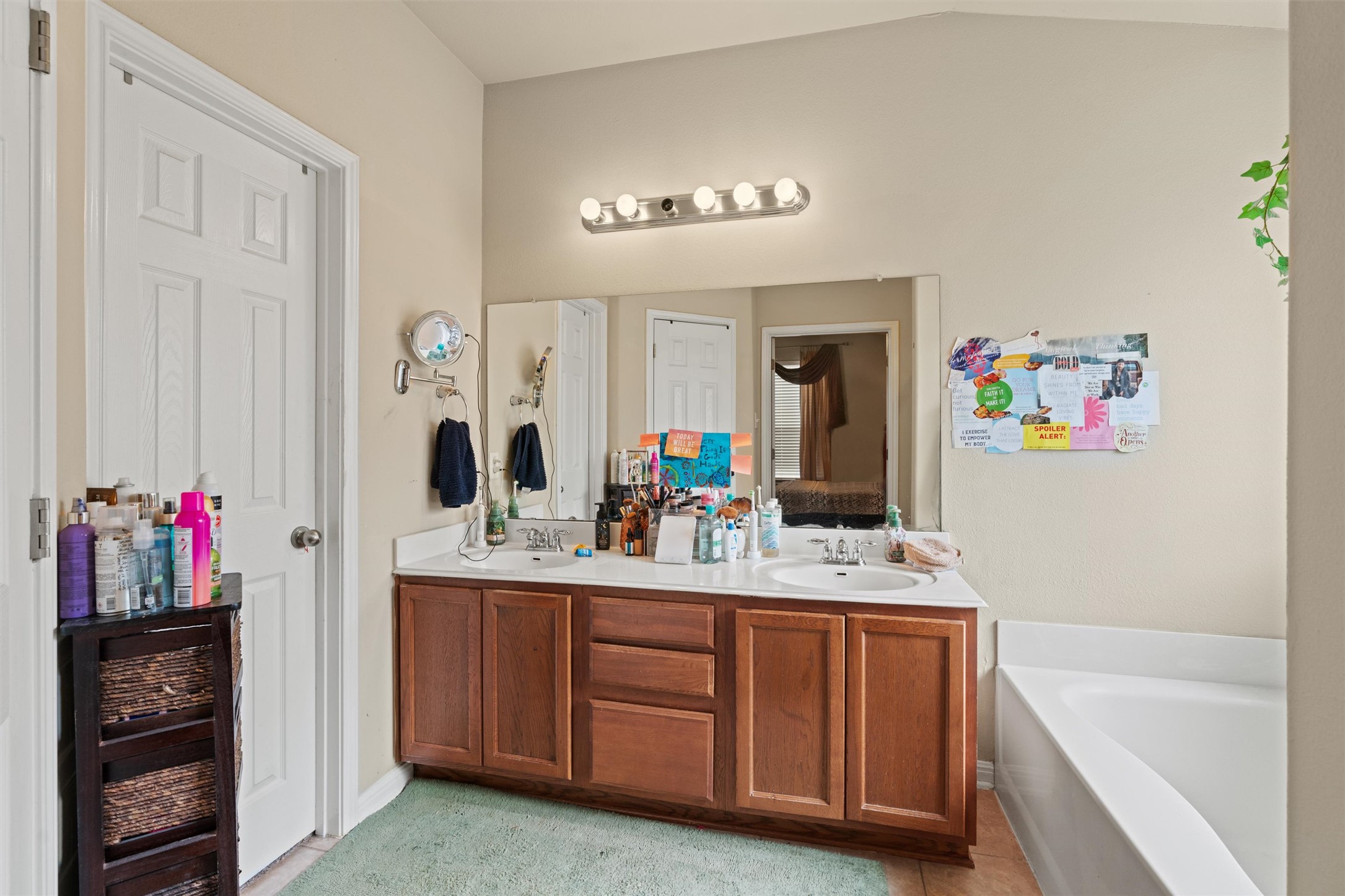 11917 Lansdowne Road Austin, TX 78754 - Photo 11 of 20 This primary bathroom offers dual sinks, a large mirror, and a spacious tub for unwinding.