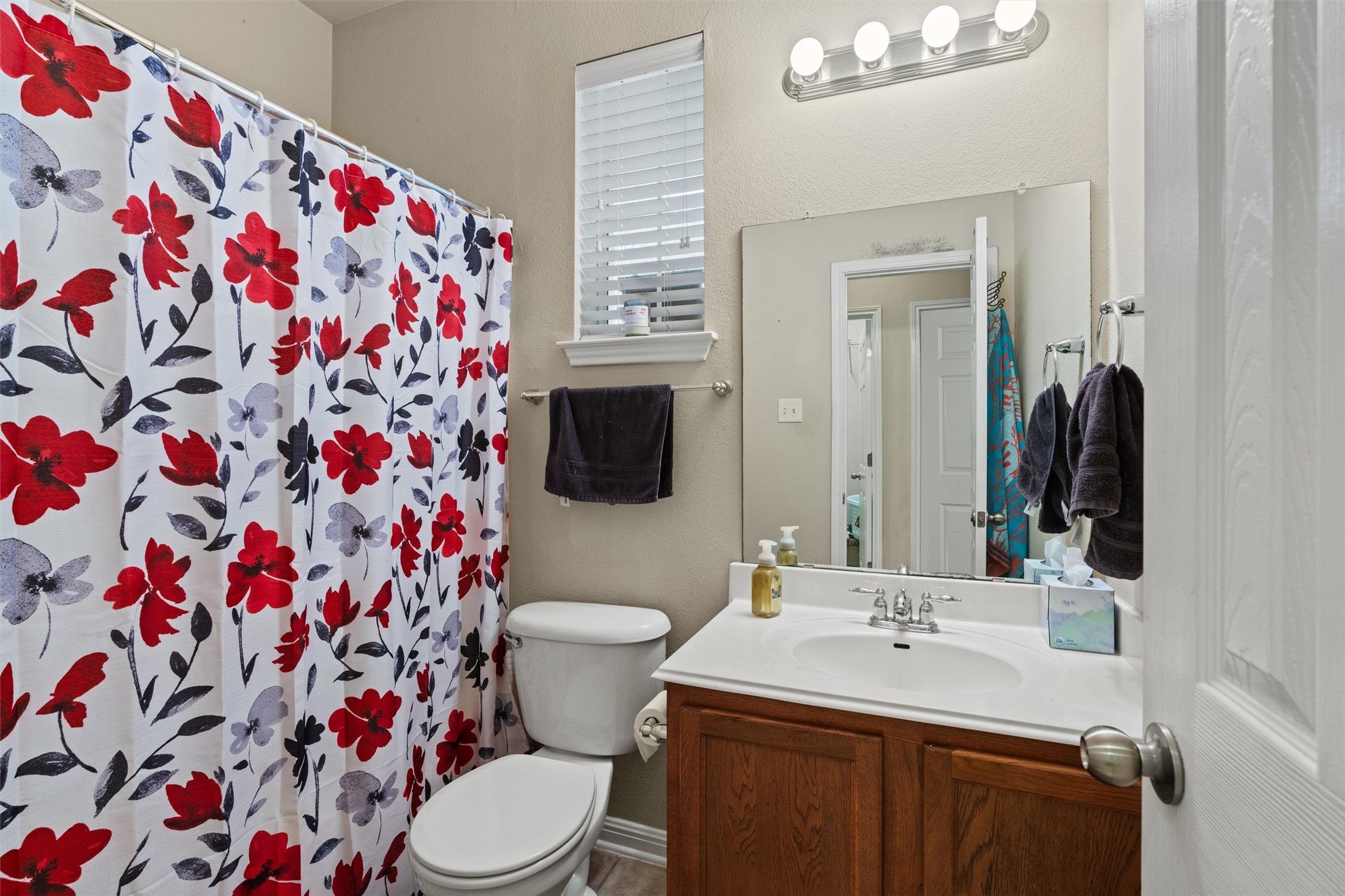 11917 Lansdowne Road Austin, TX 78754 - Photo 13 of 20 This bright bathroom features a vanity with ample storage and a shower with a vibrant curtain.