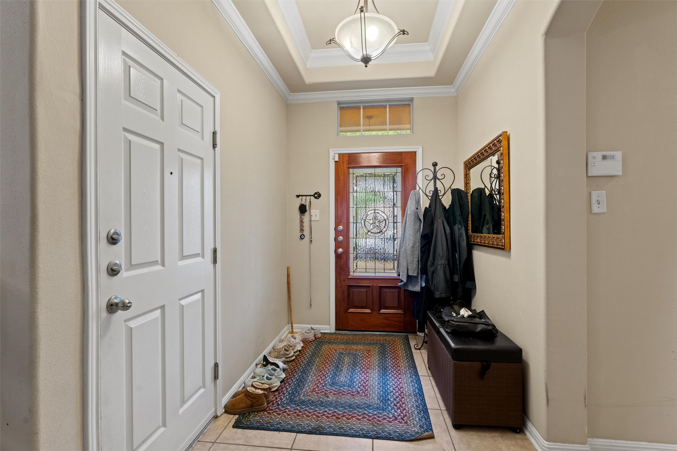 11917 Lansdowne Road Austin, TX 78754 - Photo 2 of 20 Step into this welcoming entrance foyer featuring tiled flooring and a tray ceiling with elegant lighting.