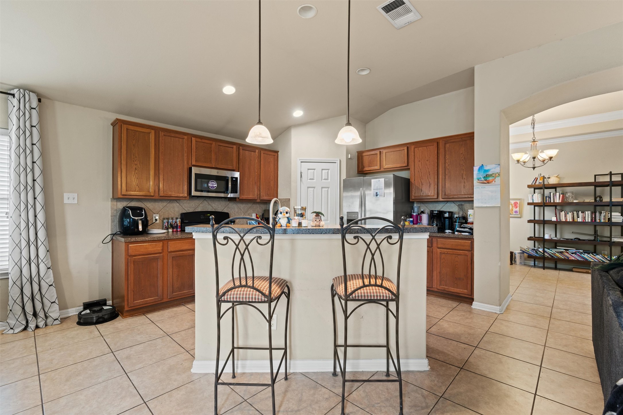 11917 Lansdowne Road Austin, TX 78754 - Photo 6 of 20 This inviting kitchen boasts a practical layout with warm wood cabinetry and a functional breakfast bar.