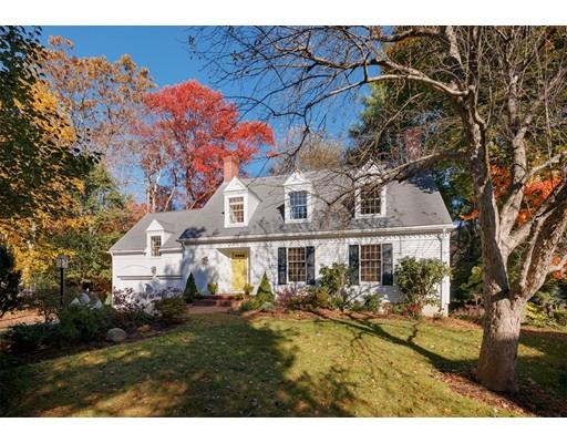 a view of a white house next to a yard with a tree