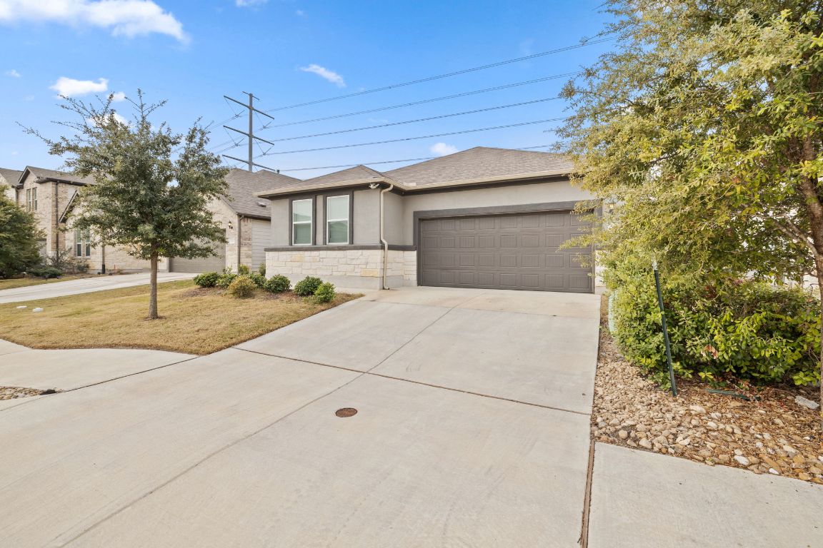 116 Thurman Holt Road Hutto, TX 78634 - Photo 2 of 35 Single story home featuring stone siding, concrete driveway, an attached garage, and stucco siding
