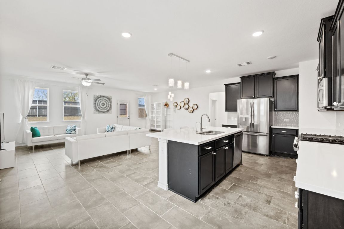 116 Thurman Holt Road Hutto, TX 78634 - Photo 35 of 35 Kitchen with pendant lighting, appliances with stainless steel finishes, an island with sink, open floor plan, and recessed lighting