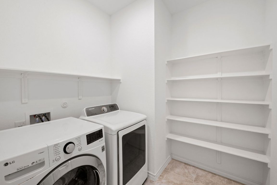 116 Thurman Holt Road Hutto, TX 78634 - Photo 19 of 35 Washroom featuring washing machine and clothes dryer and light tile patterned flooring