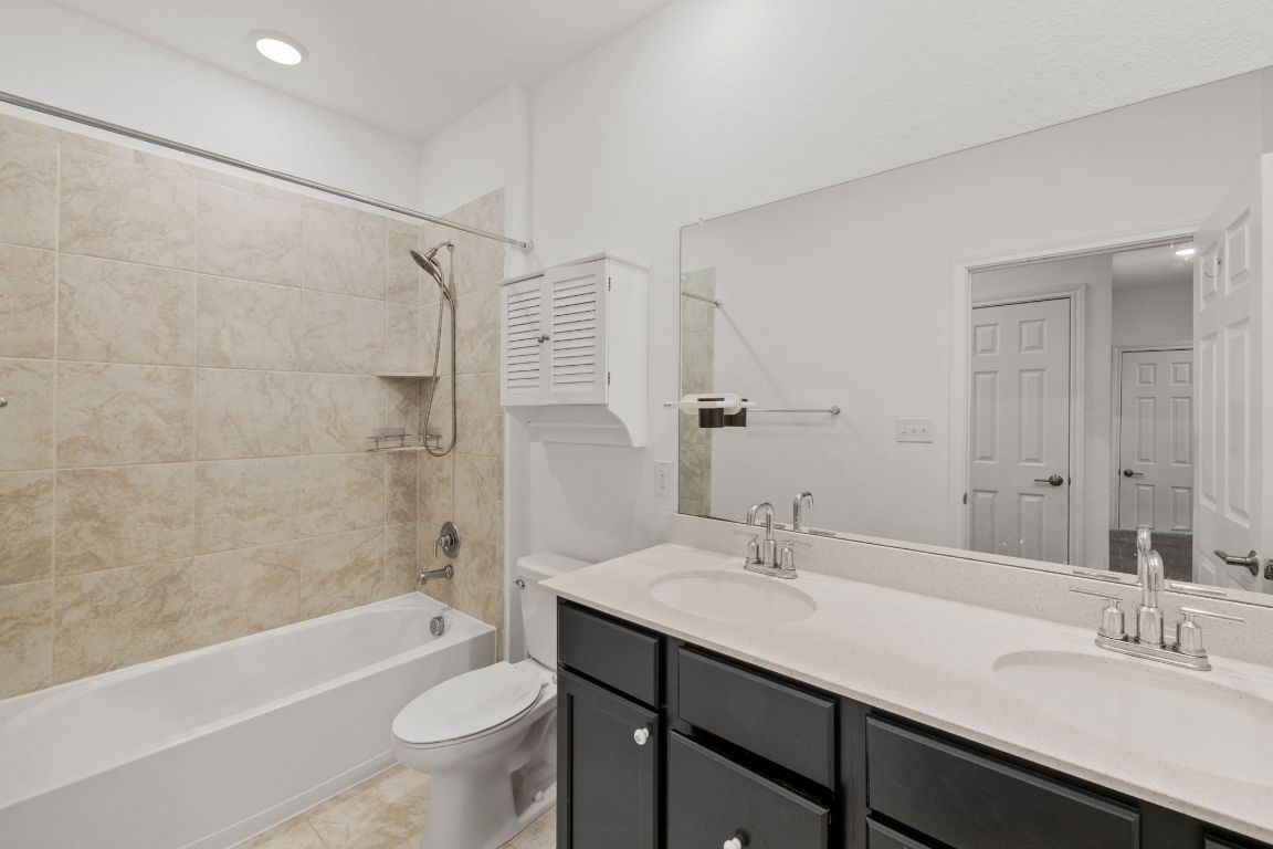 116 Thurman Holt Road Hutto, TX 78634 - Photo 22 of 35 Bathroom with double vanity and shower / bathtub combination