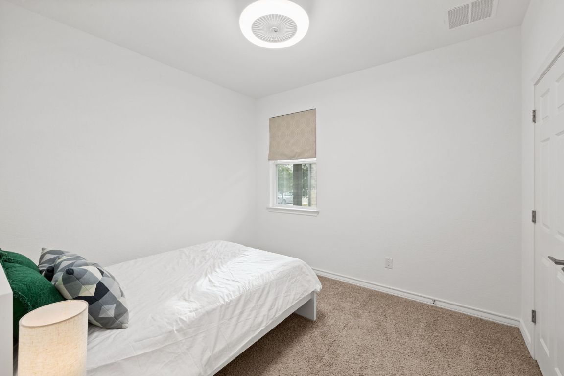116 Thurman Holt Road Hutto, TX 78634 - Photo 24 of 35 Bedroom featuring light carpet and baseboards