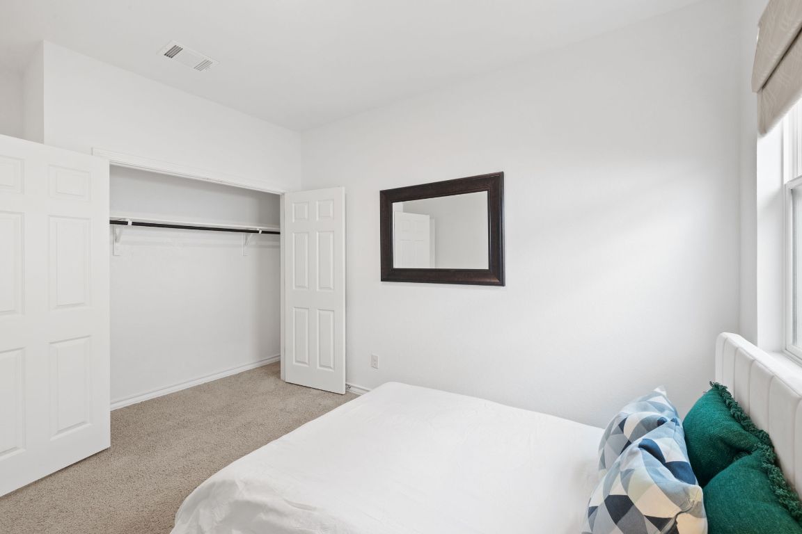116 Thurman Holt Road Hutto, TX 78634 - Photo 27 of 35 Bedroom with light colored carpet, a closet, and multiple windows