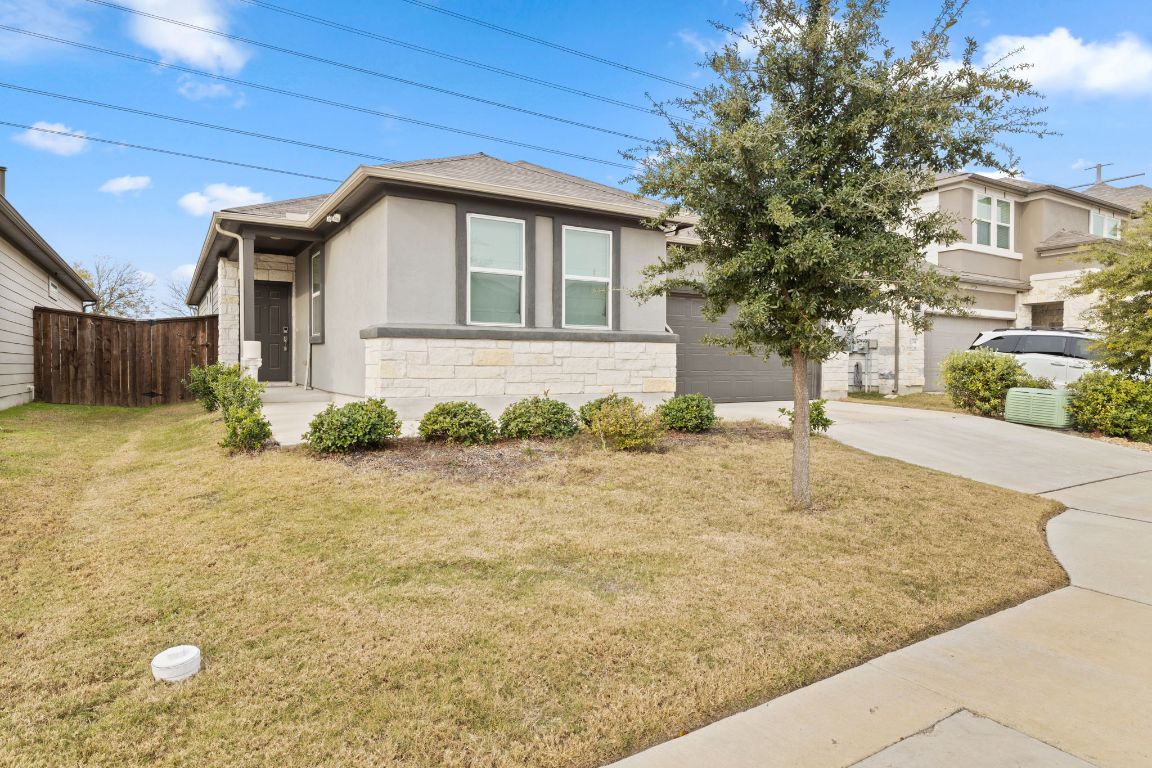 116 Thurman Holt Road Hutto, TX 78634 - Photo 3 of 35 View of front of home with concrete driveway, stone siding, stucco siding, and an attached garage