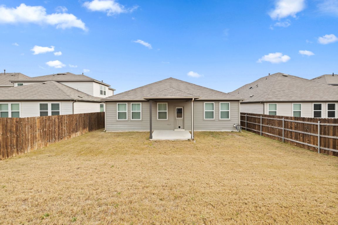 116 Thurman Holt Road Hutto, TX 78634 - Photo 32 of 35 Back of property with a patio, a fenced backyard, and roof with shingles