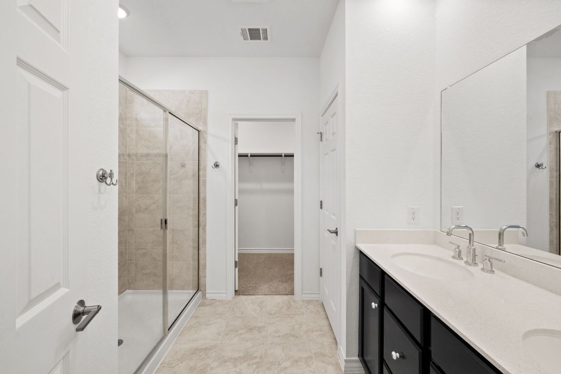 116 Thurman Holt Road Hutto, TX 78634 - Photo 9 of 35 Full bathroom featuring double vanity, a shower stall, and a spacious closet