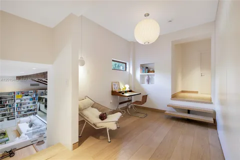 a living room with a bed furniture and a large window