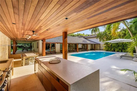 a view of a patio with table and chairs potted plants and floor to ceiling window