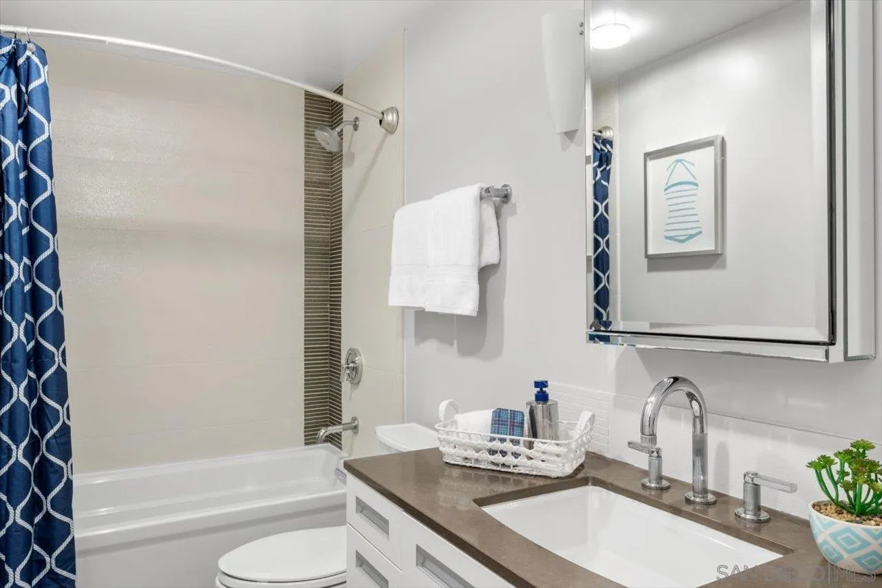 215 2nd Street, Unit 104 Encinitas, CA 92024 - Photo 6 of 22 a bathroom with a granite countertop sink toilet and shower
