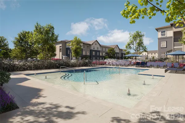 a swimming pool that has lawn chairs and a dining table under an umbrella