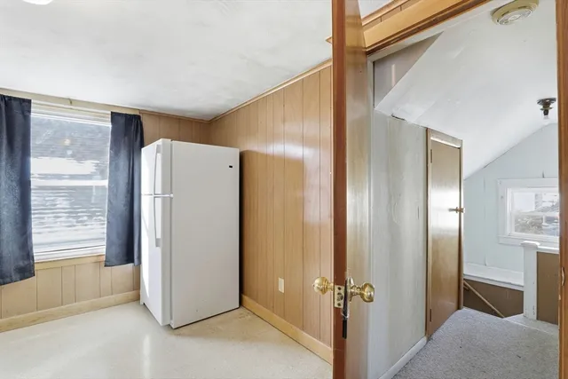 a view of a hallway with a refrigerator and a window