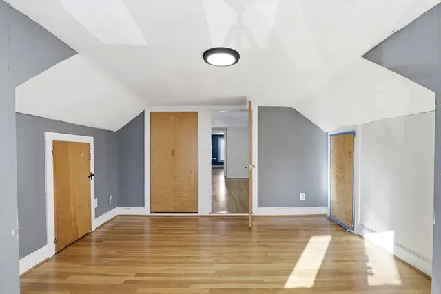 a view of a livingroom with wooden floor and bathroom
