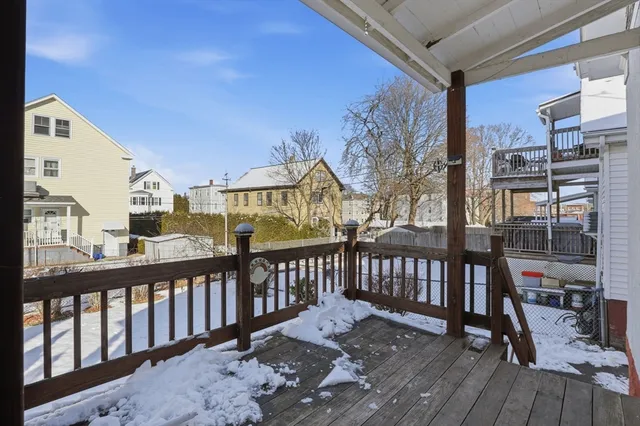 a view of a brick house with large trees and wooden fence