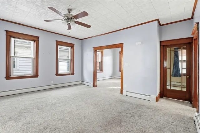 an empty room with windows and fan