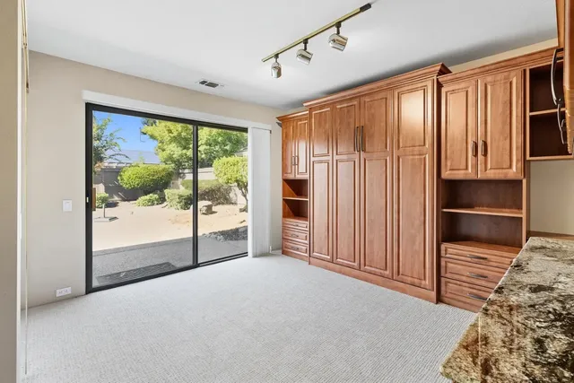 a view of an empty room with cabinet and a window