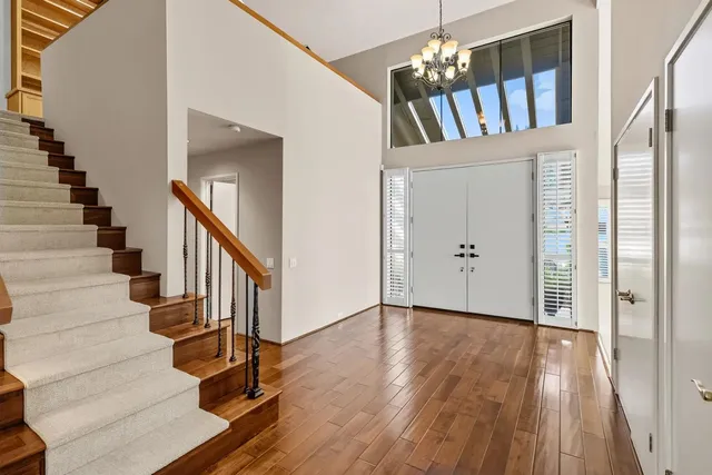 a view of a hallway with wooden floor and staircase