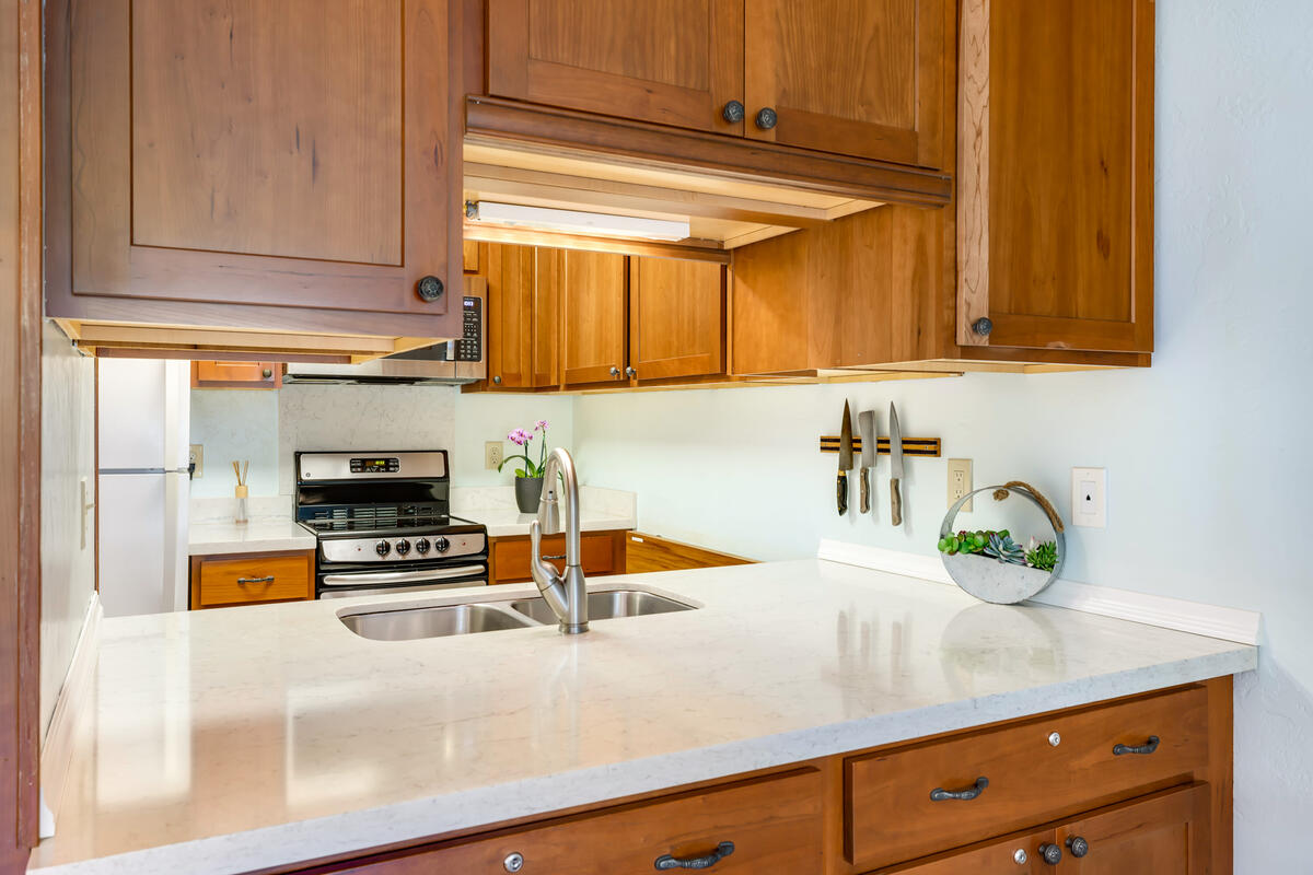 525 Aleka Loop, Unit E3 Kapaa, HI 96746 - Photo 8 of 23 a kitchen with granite countertop a sink a stove and cabinets