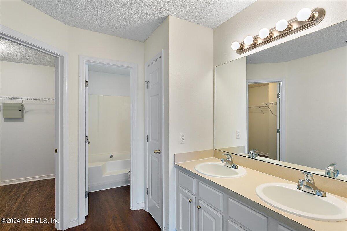 7133 High Bluff Road Jacksonville, FL 32244 - Photo 10 of 17 a bathroom with a double vanity sink and mirror with shower