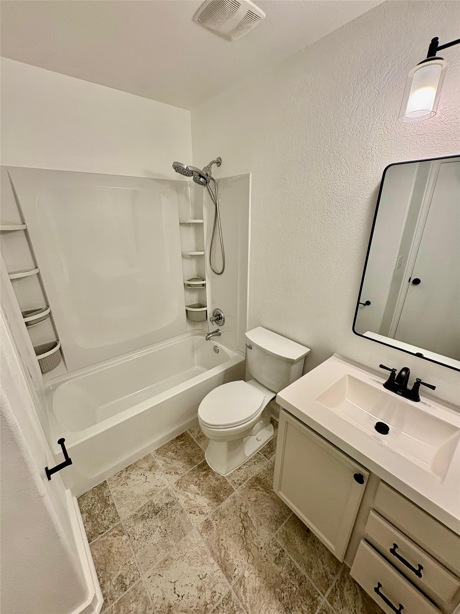 8003 Bannock Lane Austin, TX 78747 - Photo 33 of 40 Full bath with vanity, shower / bathtub combination, and a textured wall