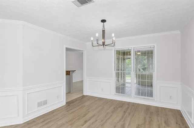 a view of empty room with wooden floor