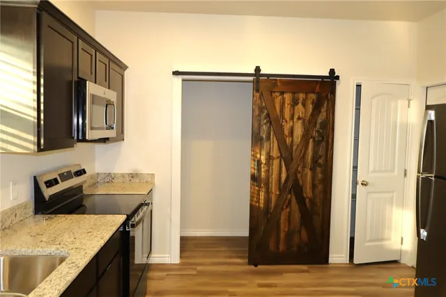 a kitchen with stainless steel appliances granite countertop a refrigerator and a sink