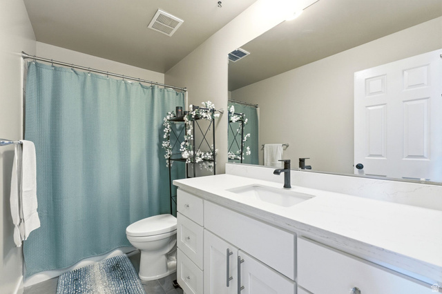 1405 Vintry Lane Murray, UT 84121 - Photo 23 of 44 Bathroom featuring a single vanity with stone-finish countertop, undermount sink, and dark-finish faucet