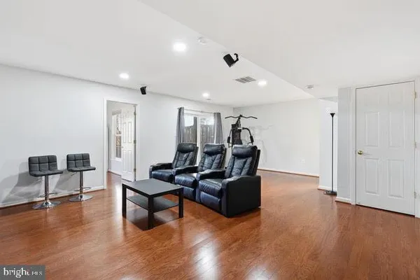 a living room with furniture and a wooden floor