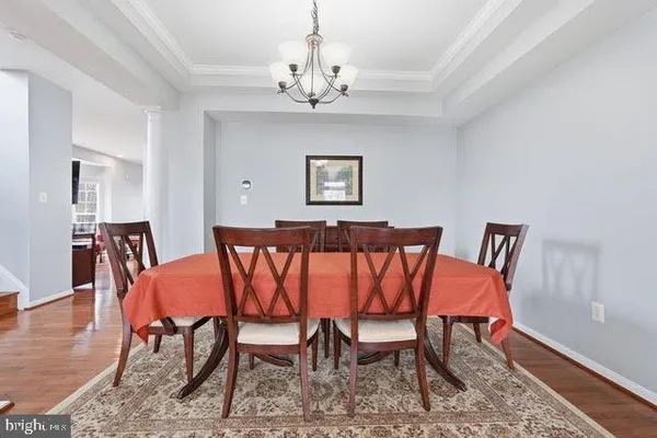 a view of a dining room with furniture wooden floor and chandelier