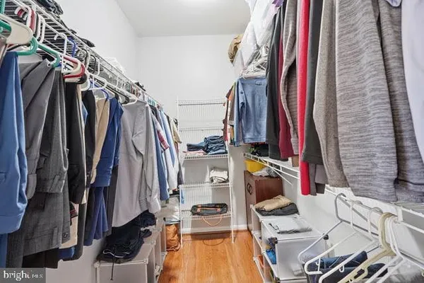 a view of walk in closet with clothes and shoes