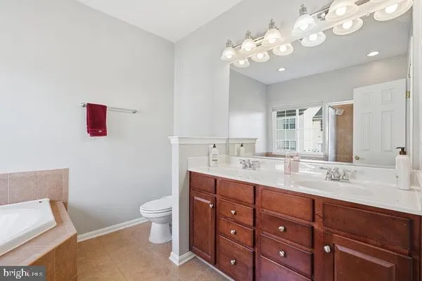 a spacious bathroom with a granite countertop sink a toilet and a mirror
