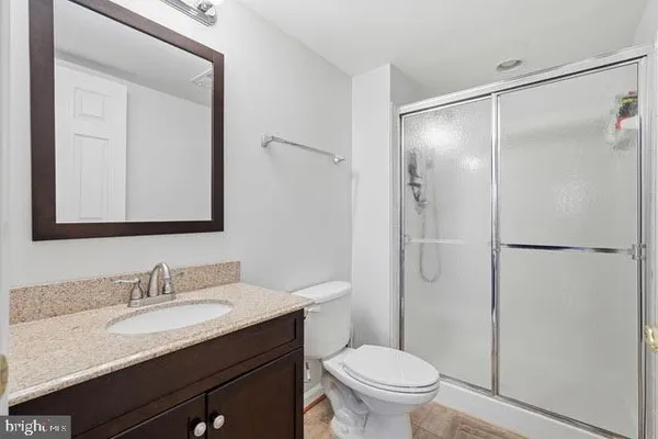 a bathroom with a granite countertop sink toilet and shower